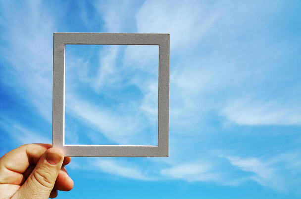 hand  holding a  frame   on  blue  sky background - Foto, immagini