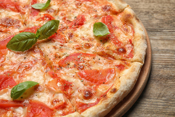 Heerlijke pizza Margherita op houten tafel, close-up uitzicht - Foto, afbeelding