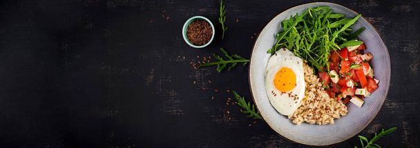 Kahvaltı yulaf lapası, kızarmış yumurta, domates salatası, roka ve keten tohumu. Sağlıklı dengeli yiyecekler. Üst görünüm, pankart, kopyalama alanı - Fotoğraf, Görsel