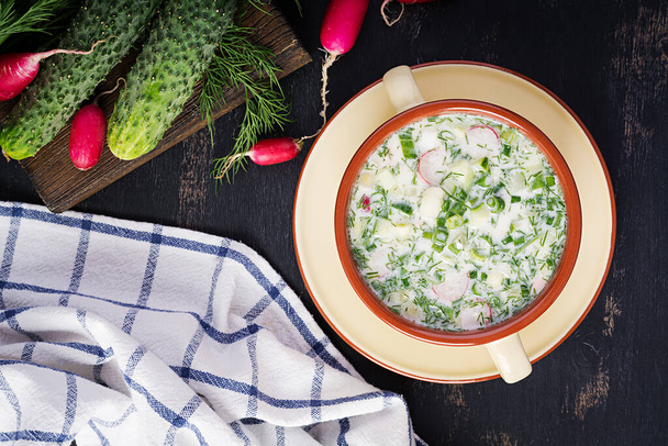 Okroshka. Kalte Sommersuppe mit Joghurt und Gemüse in Schüssel. Draufsicht, über Kopf, flache Lage - Foto, Bild