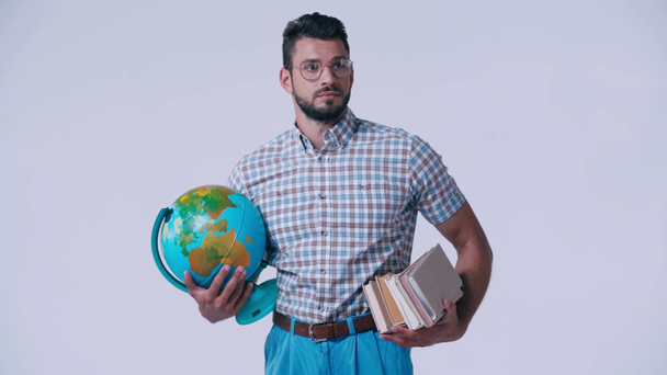 смущенный ботаник в очках с книгами и глобусом изолирован на белом
 - Кадры, видео