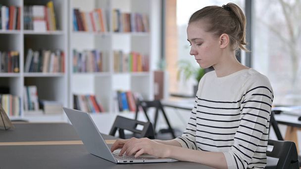 Professional Young Woman Working on Laptop in Library - Foto, Bild