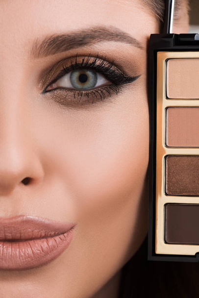Makeup. Girl with makeup and eyeshadow palette. Smokey eyes - Photo, Image