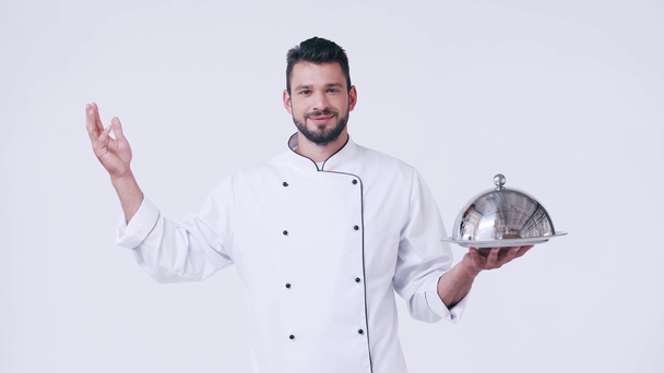chef souriant avec plat de service montrant geste bellissimo isolé sur blanc - Séquence, vidéo