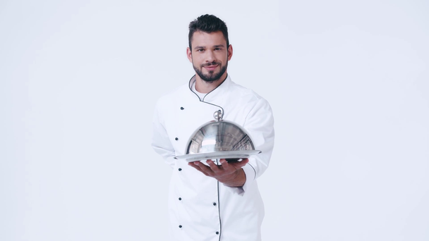 улыбающийся шеф-повар в форме, подающий блюдо и клош изолированы на белом
 - Кадры, видео