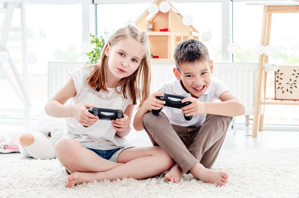 Playful kids with joysticks for gaming - Φωτογραφία, εικόνα