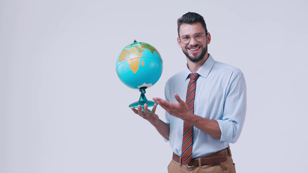 glimlachende leraar wijzend naar globe geïsoleerd op wit - Video