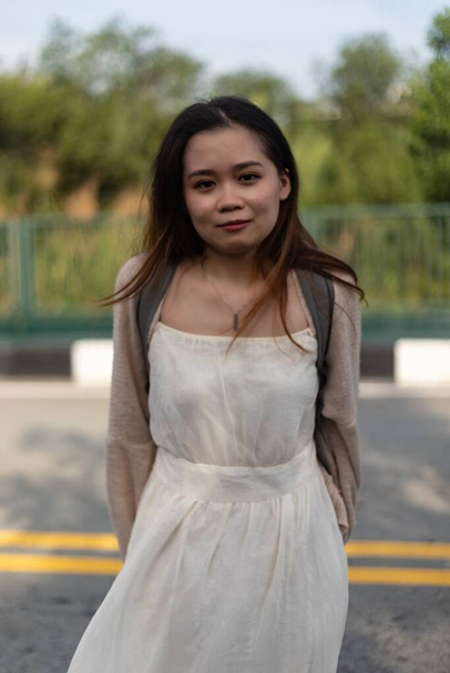 A vertical shallow focus shot of an Asian female wearing a white dress on the streets - Fotoğraf, Görsel