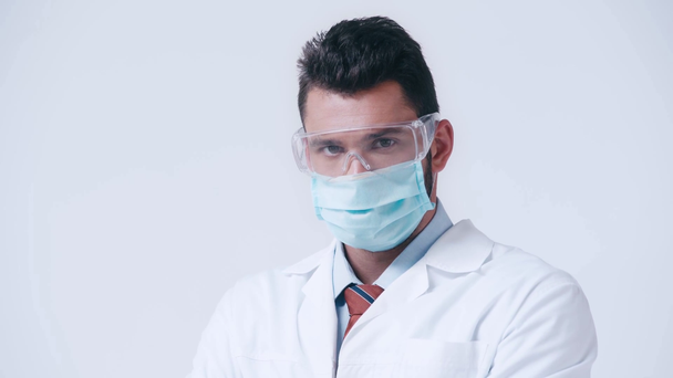 ホワイトに隔離されたゴーグルや医療用マスクの深刻な医師 - 映像、動画