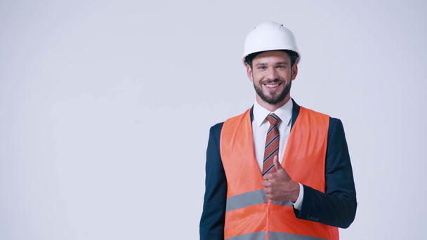 glimlachende architect in veiligheidsvest en helm tonen duim omhoog geïsoleerd op wit - Video