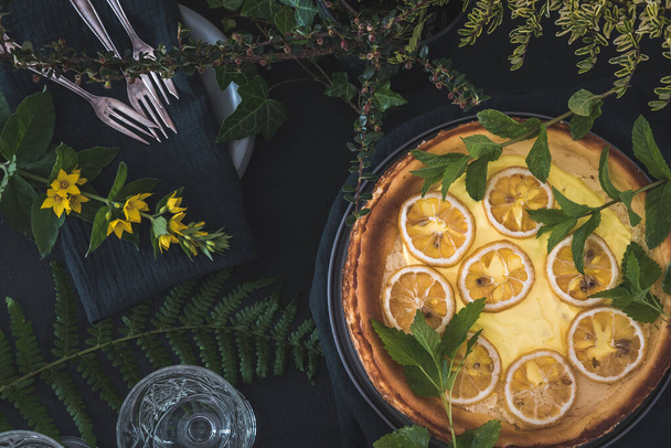 Kurumuş limon dilimli cheesecake ve siyah arka planda süsleme, üst görünüm - Fotoğraf, Görsel