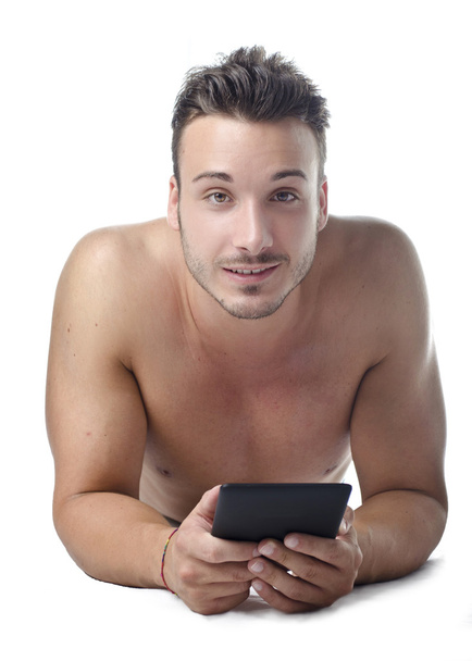 Handsome young man shirtless reading ebook on the floor - Φωτογραφία, εικόνα