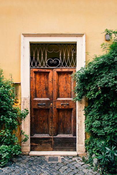 an old wooden door in the yellow wall - Fotografie, Obrázek
