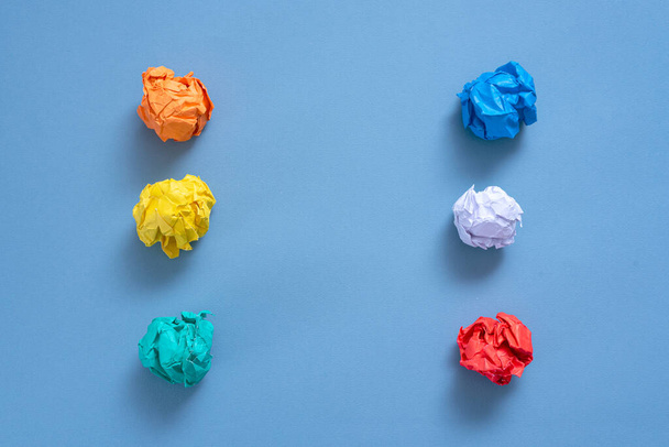 Crumpled colorful paper pages on blue background. - 写真・画像