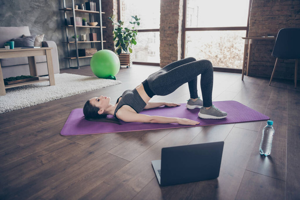 Top above high angle full body view photo athlete active energy girl have endurance intense practice watch video laptop do stretch abdomen stomach back plank on floor mat in house indoors - Fotó, kép
