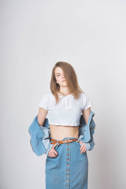 Cute girl on a white background in a photo Studio. Wearing a denim suit. Nostalgia 90's. - 写真・画像