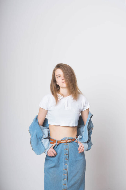 Cute girl on a white background in a photo Studio. Wearing a denim suit. Nostalgia 90's. - 写真・画像