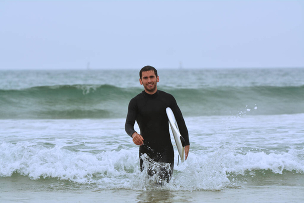 Jongeman surfen in de zee - Foto, afbeelding