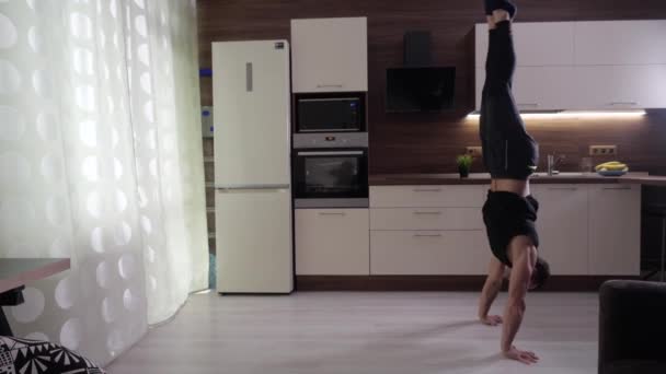 Athlete performs a difficult exercise at home - Imágenes, Vídeo