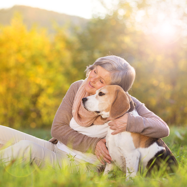 Active senior woman hugs dog - Foto, imagen