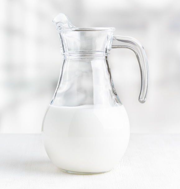 Jug of milk on the factory background. Half full pitcher - Foto, Bild