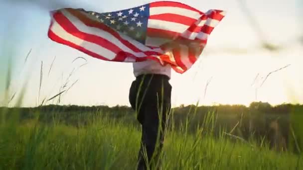 Женщина бежит с американским флагом, развевающимся на ветру. 4 июля, празднование Дня независимости. Следом следует широкоугольная камера заторможенного движения. Вид со спины. Концепция патриотического праздника, демократии и уважения ветеранов
 - Кадры, видео