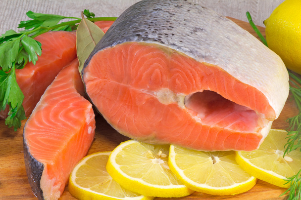 Pesce salmone, limone e verdure messi sul tavolo
. - Foto, immagini