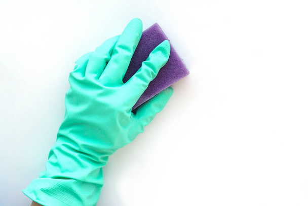 白い背景で洗うための紫色のスポンジで青いゴム手袋で手。掃除のコンセプト. - 写真・画像