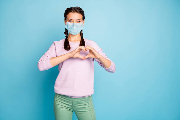 Portrait of her she nice attractive healthy girl wearing safety gauze mask showing heart sign flu flue grippe recovery therapy isolated bright vivid shine vibrant blue teal color background - Foto, immagini