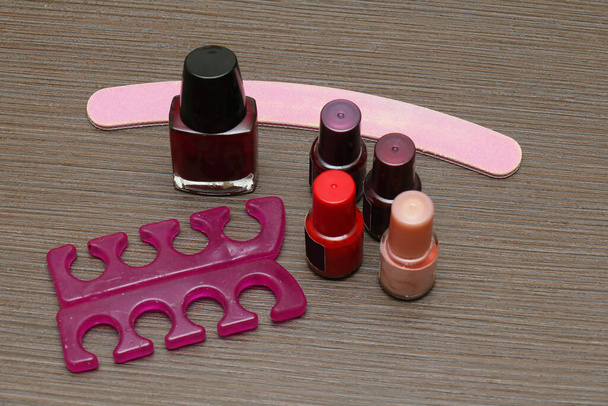 Colorful nail varnish bottles set with file and toe separators - Fotografie, Obrázek