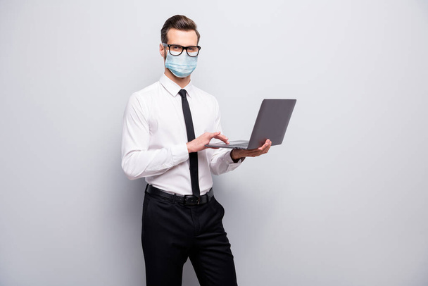 Portrait of his he nice skilled guy employer using laptop wearing safety gauze mask searching infro market research mer cov contamination prevention isolated grey color background - Fotoğraf, Görsel