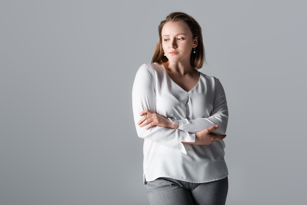 thoughtful, beautiful overweight girl standing with crossed arms isolated on grey - Φωτογραφία, εικόνα