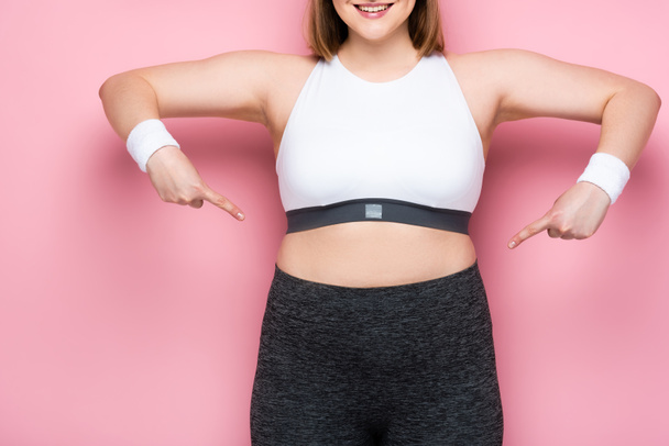 cropped view of smiling overweight girl pointing with fingers at herself on pink - Photo, Image