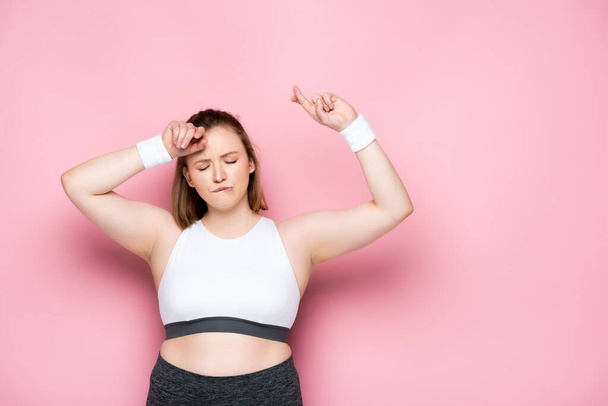 excited overweight girl dancing with closed eyes on pink - Foto, immagini