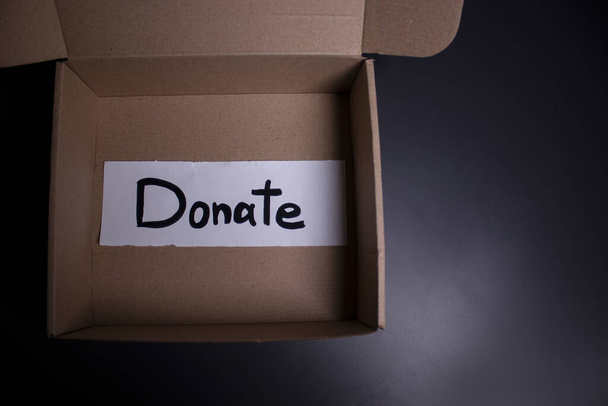 Spendenschild handgeschrieben mit schwarzen Buchstaben in einem Kasten. Spendenkonzept. Kontext der Coronavirus-Pandemie. Kopierraum - Foto, Bild
