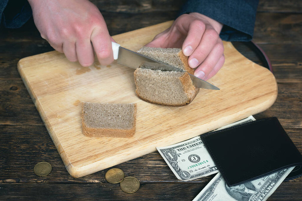 Poverty. Financial problem. Debts. Money problems. Poor businessman is preparing a lunch consist of bread. - Foto, Imagem