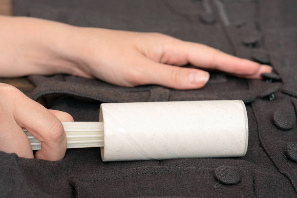 Woman cleans clothes with a cleaning roller close up. - Photo, image