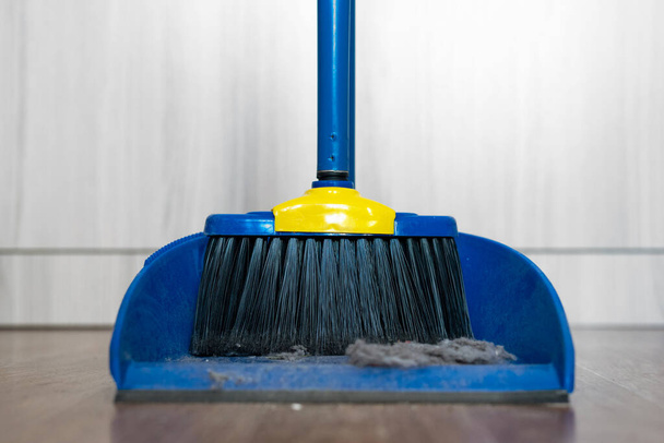 Sweeping brush and a dust on a floor. - Foto, afbeelding