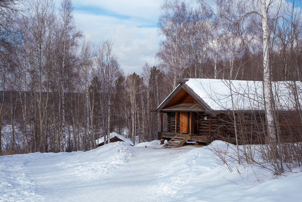 Wooden old house in the forest in snowy winter. - Foto, afbeelding