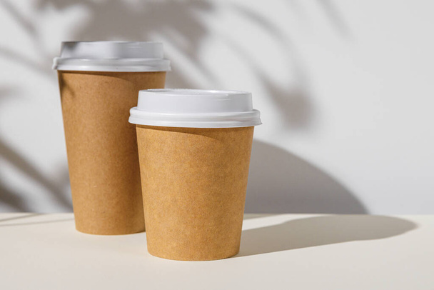 Takeout coffee cup with foliage shadows, copy space - 写真・画像