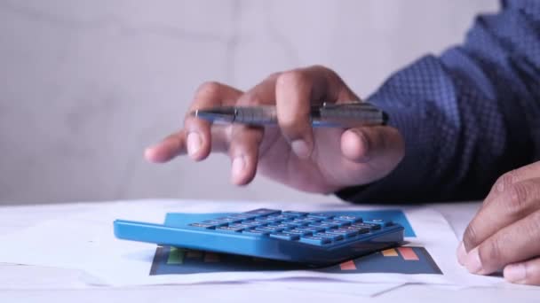 zbliżenie człowieka za pomocą kalkulatora na biurku - Materiał filmowy, wideo