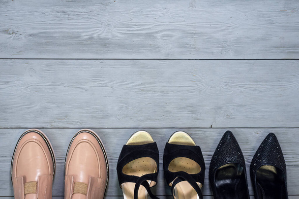Various footwear on a wooden floor background with copy space. - Foto, afbeelding