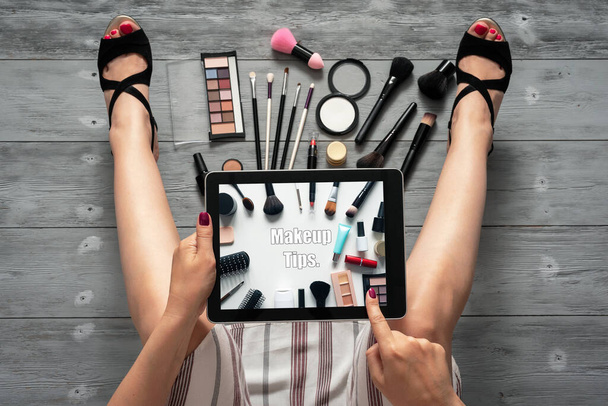 Make up tips concept. Woman is reading a makeup tips from her digital tablet. - Photo, Image