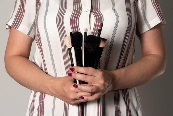Makeup artist with a makeup brushes in hands close up. - Foto, imagen