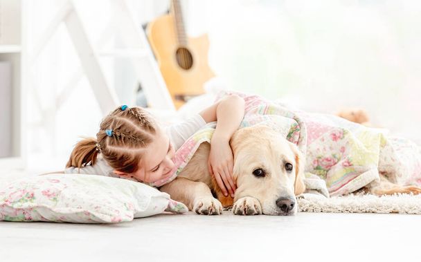 Beautiful little girl covering cute dog - Фото, изображение