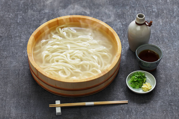 kamaage udon is a kind of japanese udon noodes dish, plain hot udon noodles in wooden pail and dipping sauce - Photo, Image