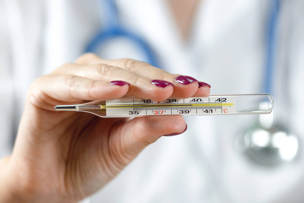 Doctor woman showing thermometer with a high body temperature. - Foto, Bild