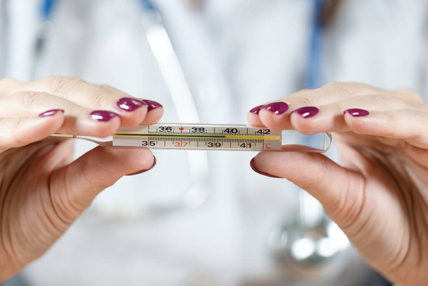 Doctor woman showing thermometer with a high body temperature. - Foto, Bild