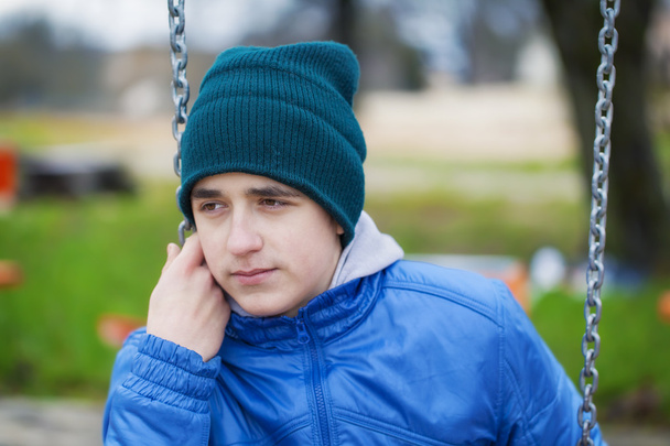 bolesna nastoletniego chłopca, kołysząc się w parku - Zdjęcie, obraz