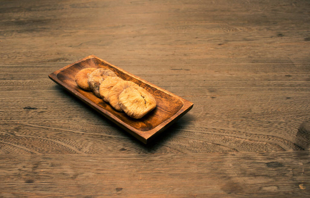Fig in wood platter on wood background - Фото, изображение